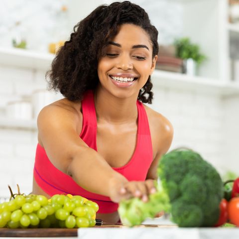 Frau greift nach Gemüse, Kochbuch gesunde Ernährung