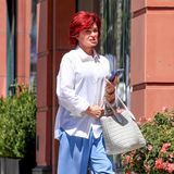 In diesem coolen Baggy-Look ist Sharon Osbourne unterwegs in Beverly Hills. Sie trägt ein weißes, lockeres Hemd und kombiniert dazu eine weite Hose in pastelligem Blau. Das ganze Outfit ist in hellen Tönen gehalten, die Handyhülle passt exakt zur Hose. Hingucker bei Sharon: ihre feuerrote Mähne.