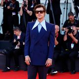 Retro kann er: Popstar und nun auch Schauspieler Harry Styles gibt sich im blauen Zweireiher mit hellem Hemd samt extralangem Kragen,weißen Boots und großer Sonnebrille betont lässig.