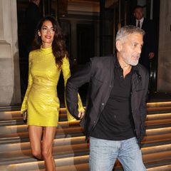 Auf dem Weg zur "Ticket To Paradise"-Afterparty erhellt Amal mit George an ihrer Hand in einem gelb glitzernden Minidress mit Glockenärmeln die Londoner Nacht wie eine Sonne.