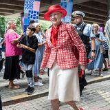 Beim Besuch der Kommune Frederiksberg mit der Königsyacht Dannebrog zeigt sich Königin Margrethe in den Farben ihres Landes. Zum weißen Rock kombiniert sie ein weiß-rot-kariertes Jackett. Auch die Accessoires sind rot, Schuhe, Einstecktuch und Hut erstrahlen in dem kräftigen Farbton.