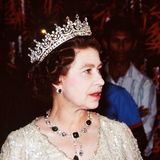 Bei einem Bankett in Papua Neu-Guinea 1982 trägt die Queen neben der "Girls of Great Britain and Ireland"-Tiara auch die "Cambridge und Delhi Durbar Parure", ein Juwelen-Set das aus einer Smaragd-Halskette sowie passenden Ohrringen besteht.