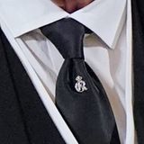 Die Brosche, die der neue König an seiner schwarzen Krawatte gesteckt trägt, zieren ein ein großes C und ein großes R. Sie stehen für "Charles Rex". 