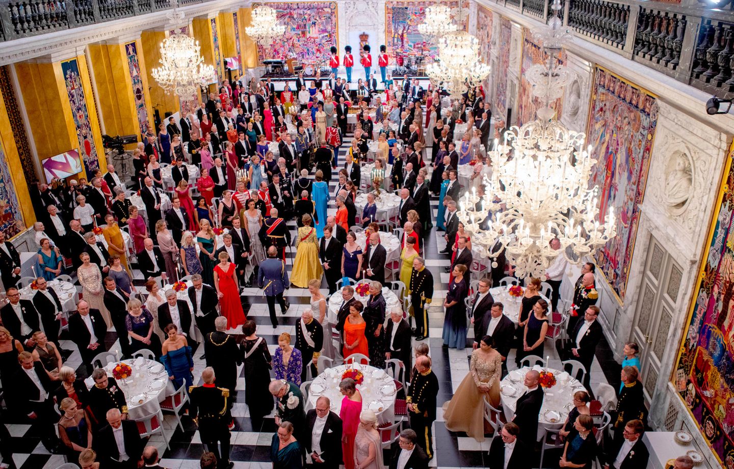 Auch im feierlich geschmückten Ballsaal des Schlosses erheben sich alle Gäste zu Ehren der Königin und ihrer royalen Gäste