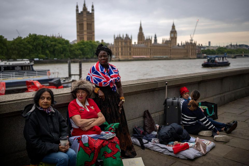 Passant:innen vor dem Westminsterpalast warten darauf, als Erste in der Schlange zu stehen, um von Queen Elizabeth am 13. September 2022 in London Abschied zu nehmen.
