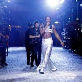 Rapper Lil Nas darf die aufwendig inszenierte Fashion Show abschließen und brilliert in einem silberfarbenen Zweiteiler. Das Crop-Top gewährt den Zuschauer:innen freie Sicht auf seinen stahlharten Sixpack. 