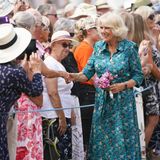 In einem lebhaften und farbenfrohen Look begrüßt Königin Camilla die Besucher der Flower Show in Sandringham. Sie entscheidet sich für ein luftiges, blaugrünes Hemdkleid mit floralem Muster. Mit dem sommerlichen Midikleid trifft sie haargenau das Motto des Anlasses. 