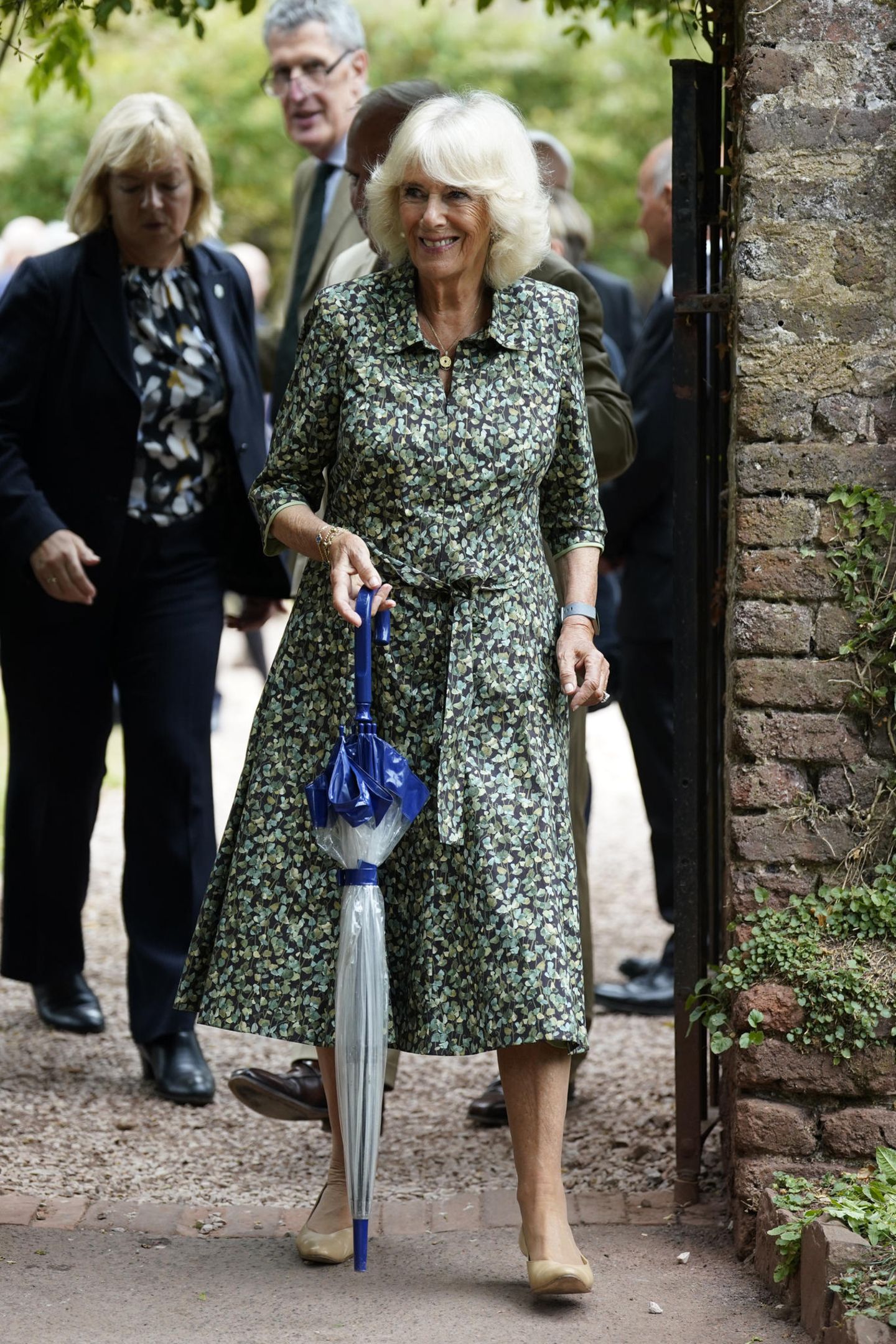 Beim Besuch in einem Kreativitätszentrum in Cockington Court setzt Königin Camilla auf ihren Statement-Look. Immer wieder begeistert sie in floralen Hemdkleidern. Dieses wunderschöne Exemplar hat einen Gürtel an der Taille, wodurch ihre Figur betont wird. 