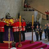 Der Sarg von Queen Elizabeth trifft in der Westminster Hall ein, begleitet von ihren Kindern und Enkelkindern sowie deren Partner:innen, die sich im Hintergrund versammelt haben.