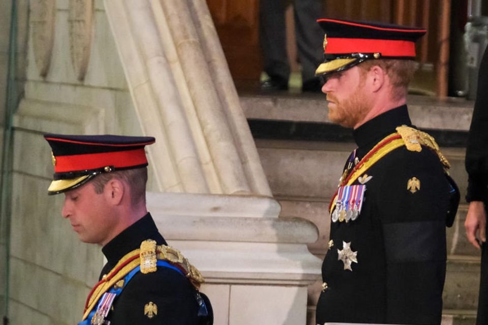 Ein genauer Blick auf die Schultern von Prinz William und Prinz Harry lohnt sich: Während bei William die Initialen auf der goldenen Bordüre zu finden sind, sind diese bei Harry verschwunden.