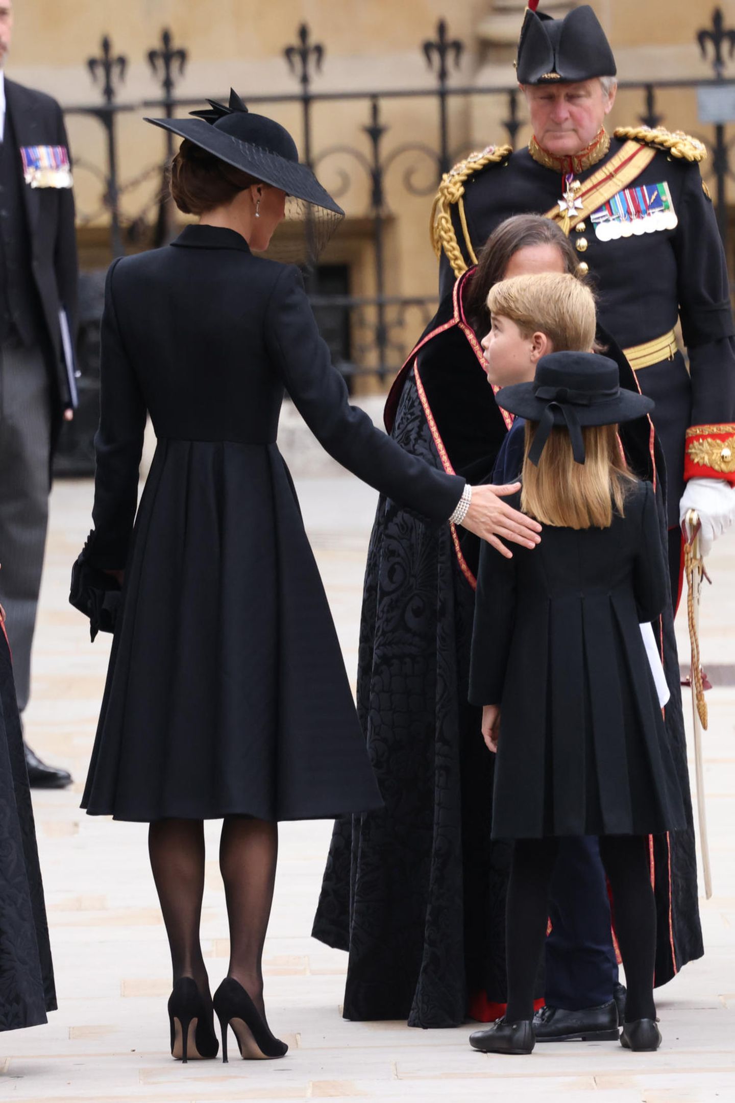 Von hinten ist noch besser erkennbar, dass Charlottes Look quasi eine Kinderversion des Outfits ihrer Mutter, Herzogin Catherine ist. Beide Mäntel haben in Falten gelegte Röcke und sind an der Taille akzentuiert. 