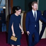 2018 trug Meghan das Kleid von der Designerin ihres zweiten Hochzeitskleides mit einer durchsichtigen Strumpfhose und blauen Pumps. Das Haar hatte sie zwar auch hochgesteckt, jedoch sehr viel lockerer als zur Beerdigung. Besonderer Hingucker war damals die kastige Clutch mit Sternenbild. 