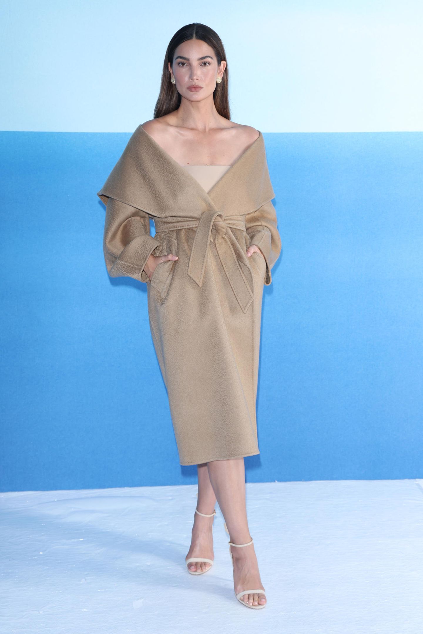 Lily Aldridge zählt zu den Gästen der Show von Max Mara in Mailand. Sie trägt einen für das Label typischen Mantel, den sie locker knotet, sodass er ihr über die Schultern rutscht. 