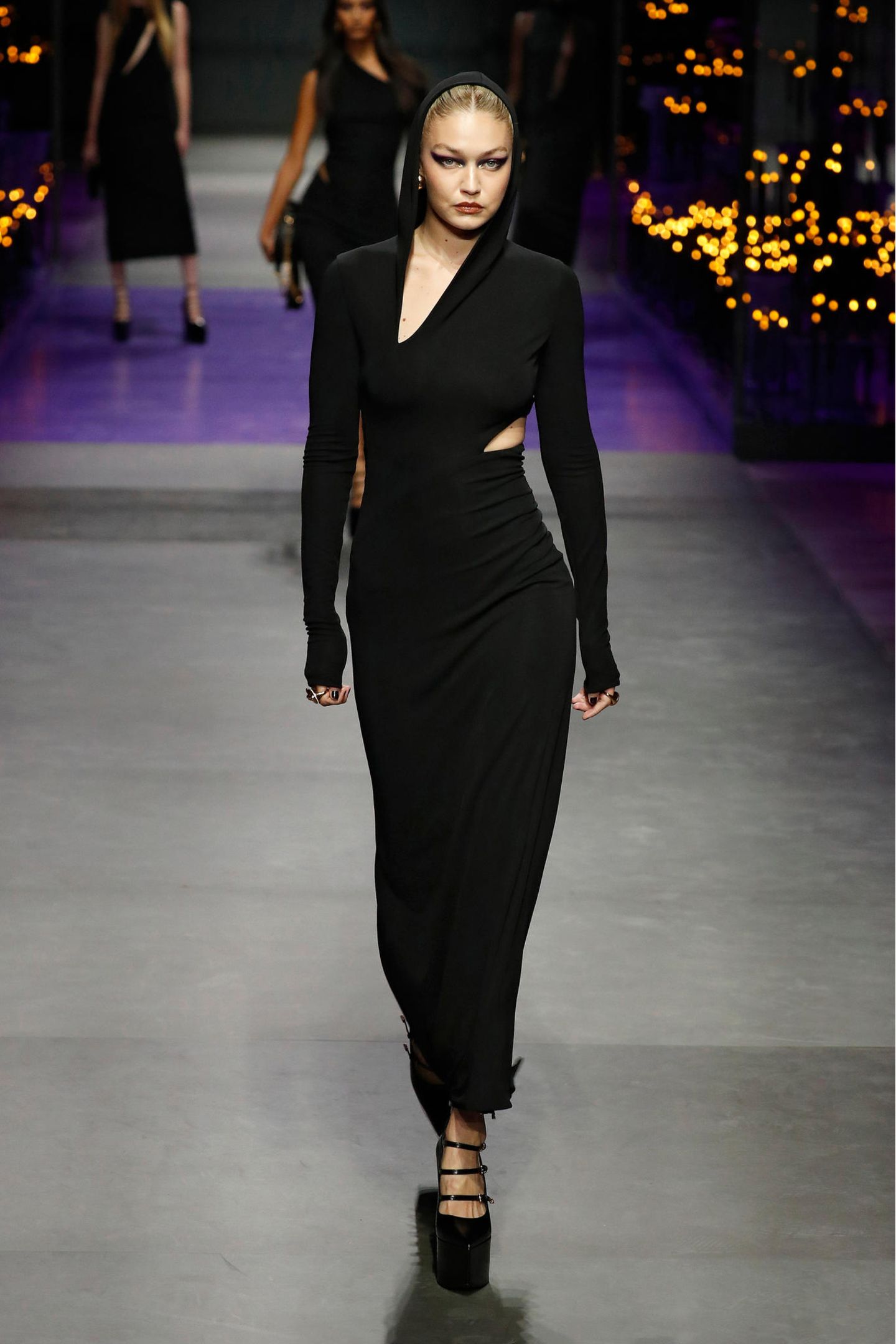 Auch Schwester Gigi ist bei Versace engagiert. Sie zeigt auf dem Laufsteg eine schwarzes Ganzkörperkleid mit raffinierten Cut-Outs. 