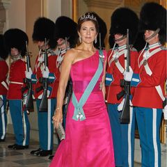 Für ein Galabankett auf Schloss Christiansborg anlässlich des 50. Thronjubiläums der dänischen Königin Margrethe wählt Prinzessin Mary einen besonders eleganten Look. Im fuchsiafarbenen One-Shoulder-Abendkleid von David Andersen macht die gebürtige Australierin eine hervorragende Figur. Warum? Der Schnitt betont ihre schlanken Schultern, die Farbe lässt Marys Teint leuchten. Zu dem auffälligen Dress kombiniert Mary Satin Pumps von Gianvito Rossi im gleichen "Hot Pink" sowie Diamantohrringe von Bruun Rasmussen. Ihre Hochzeitstiara mit blattförmig arrangierten Diamanten setzt ein weiteres Highlight.