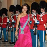 Für ein Galabankett auf Schloss Christiansborg anlässlich des 50. Thronjubiläums der dänischen Königin Margrethe wählt Prinzessin Mary einen besonders eleganten Look. Im fuchsiafarbenen One-Shoulder-Abendkleid von David Andersen macht die gebürtige Australierin eine hervorragende Figur. Warum? Der Schnitt betont ihre schlanken Schultern, die Farbe lässt Marys Teint leuchten. Zu dem auffälligen Dress kombiniert Mary Satin Pumps von Gianvito Rossi im gleichen "Hot Pink" sowie Diamantohrringe von Bruun Rasmussen. Ihre Hochzeitstiara mit blattförmig arrangierten Diamanten setzt ein weiteres Highlight.
