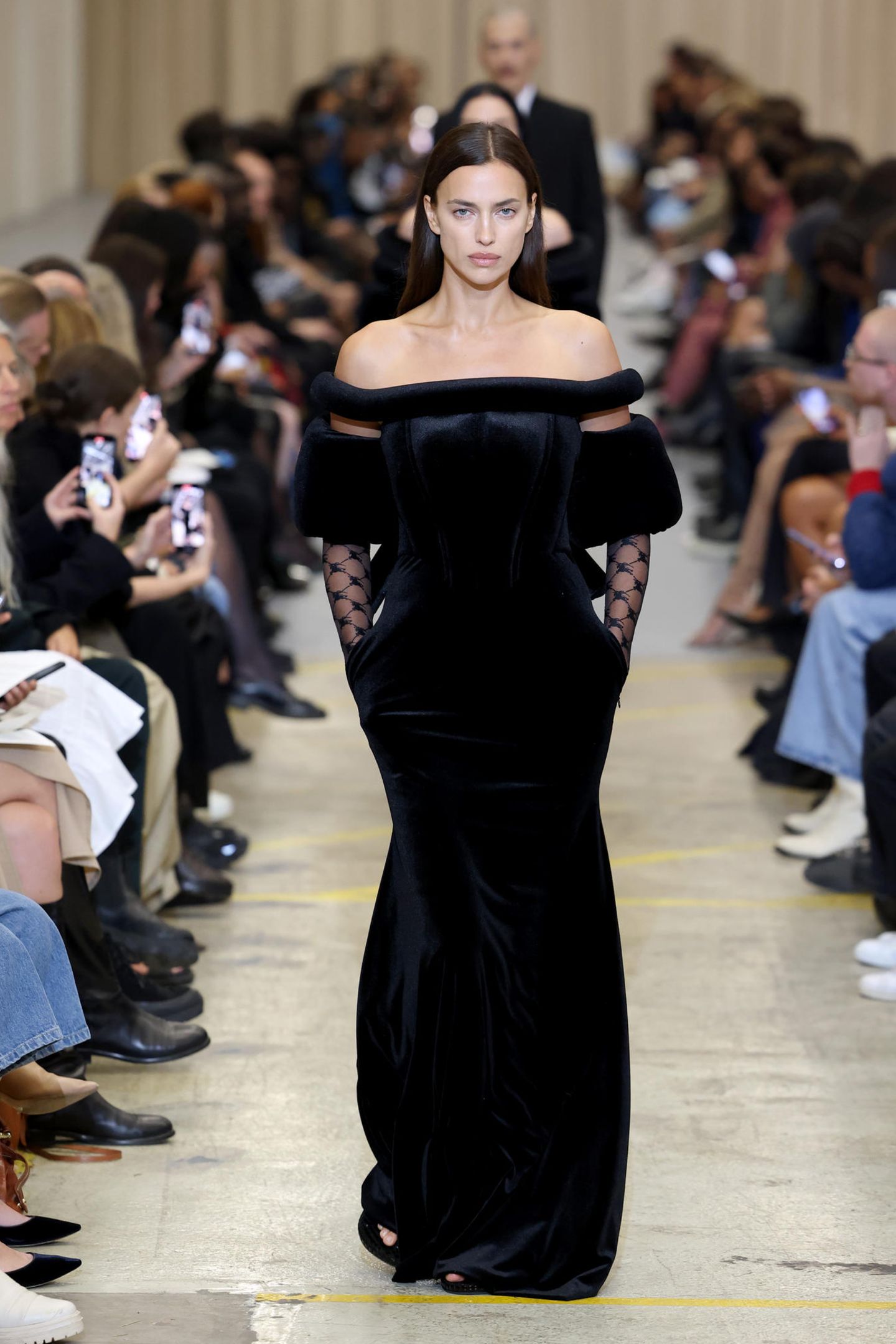 Ein klassischer Frühling-Sommer-Look ist das, was Supermodel Irina Shayk bei der Show von Burberry präsentiert, nicht gerade. Das schwarze Maxikleid mit Carmen-Ausschnitt kommt mit Korsage, Fellbesatz und Spitzenärmeln daher.