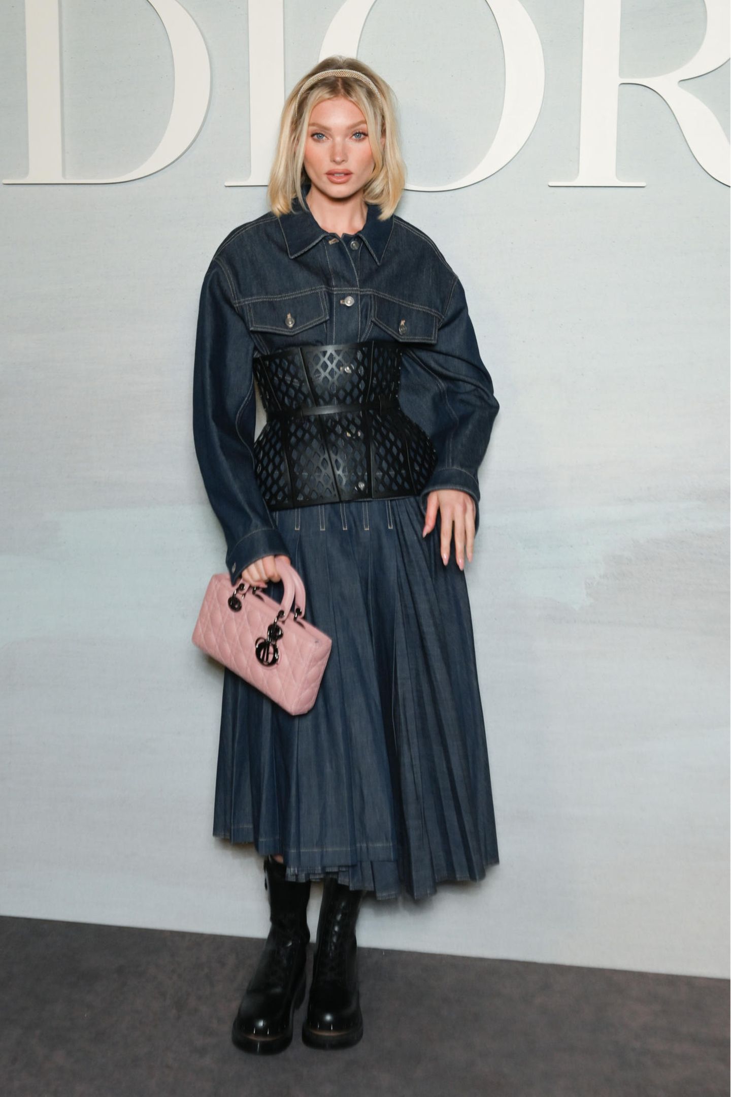 Elsa Hosk lässt sich die Modenschau von Dior nicht entgehen. Für das Event greift sie zum langen Jeanskleid mit Korsage und derben Boots. Zum Blickfang des Outfits wird die babyrosa Tasche. 