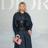 Elsa Hosk lässt sich die Modenschau von Dior nicht entgehen. Für das Event greift sie zum langen Jeanskleid mit Korsage und derben Boots. Zum Blickfang des Outfits wird die babyrosa Tasche. 
