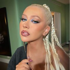 Christina Aguilera scheint selbst ganz begeistert von ihrem Augen-Make-up zu sein: Gleich mehrere Fotos und Reels von ihrem Look postet die Sängerin auf Instagram. Und auch wir lieben den blauen Kajalstrich auf der Wasserlinie sowie den Lidschatten im selbigen Ton auf der Augen-Innenseite. Fake-Lashes und ein schwarzer Lidstrich sorgen für einen Cat-Eye-Effekt. Gloss-Lippen im Ombré-Stil runden den Look perfekt ab. 
