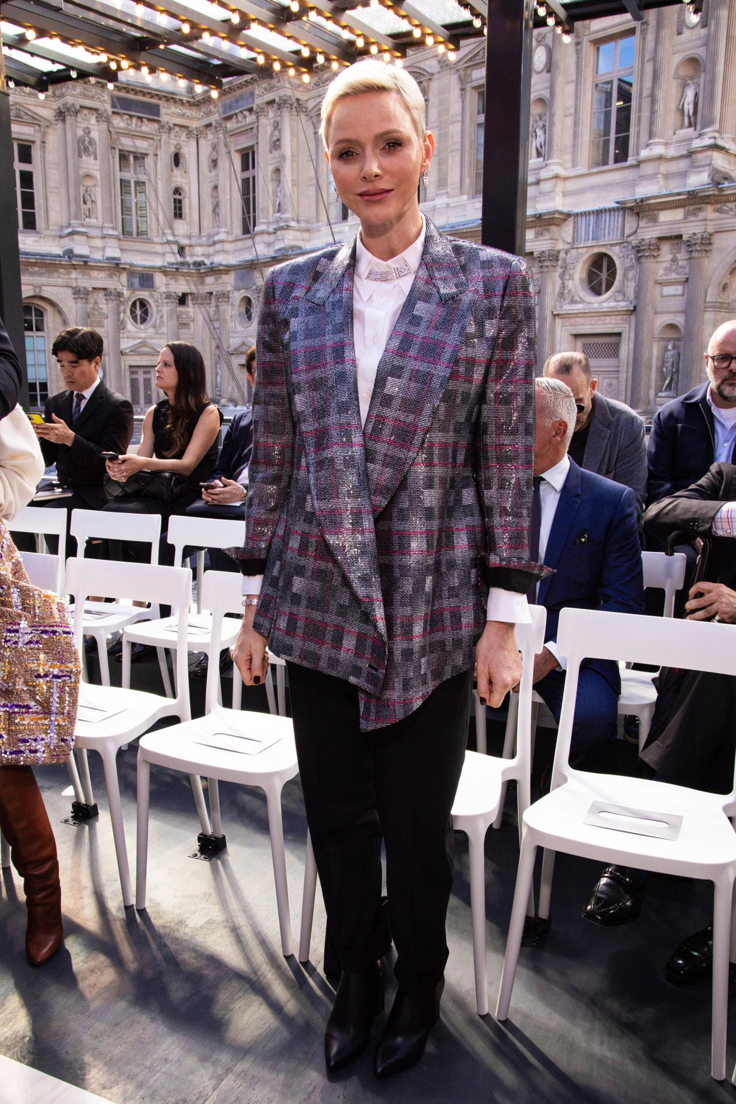 Auch Fürstin Charlène gehört zu den vielen Stargästen der Louis-Vuitton-Show. Im karierten Blazer des Labels vereint sie Glamour und 80s-Style.