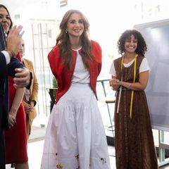 Königin Rania besucht das Team der Makesy App und trägt dabei ein Kleidungsstück, das wir selten zuvor an ihr gesehen haben. Ihren weißen Midirock mit Blumenmuster am Saum kombiniert sie nämlich zu einem schlichten weißen T-Shirt. Doch mit der extravaganten roten Jacke darüber bekommt selbst das Casual-Shirt elegantes Flair.