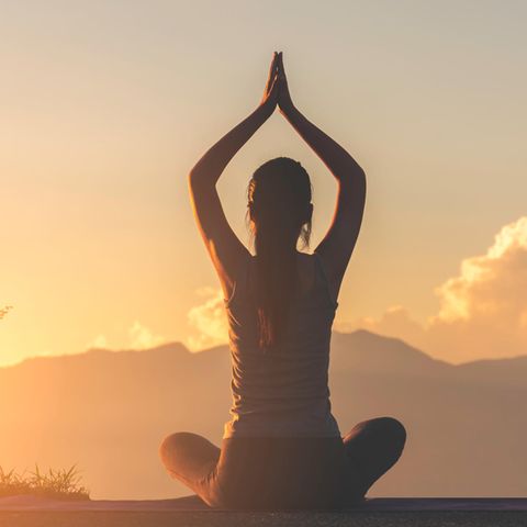 Horoskop: Frau in Yoga-Pose auf einem Berg