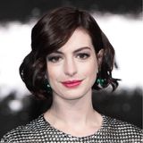 2014  Anne Hathaway strahlt silbern in einem langärmeligen Gordon-Wes-Kleid. Ihren Metallic-Look zur europäischen "Interstellar"-Premiere ergänzt sie mit pinkem Lippenstift und auffälligen smaragdgrünen Tropfenohrringen.