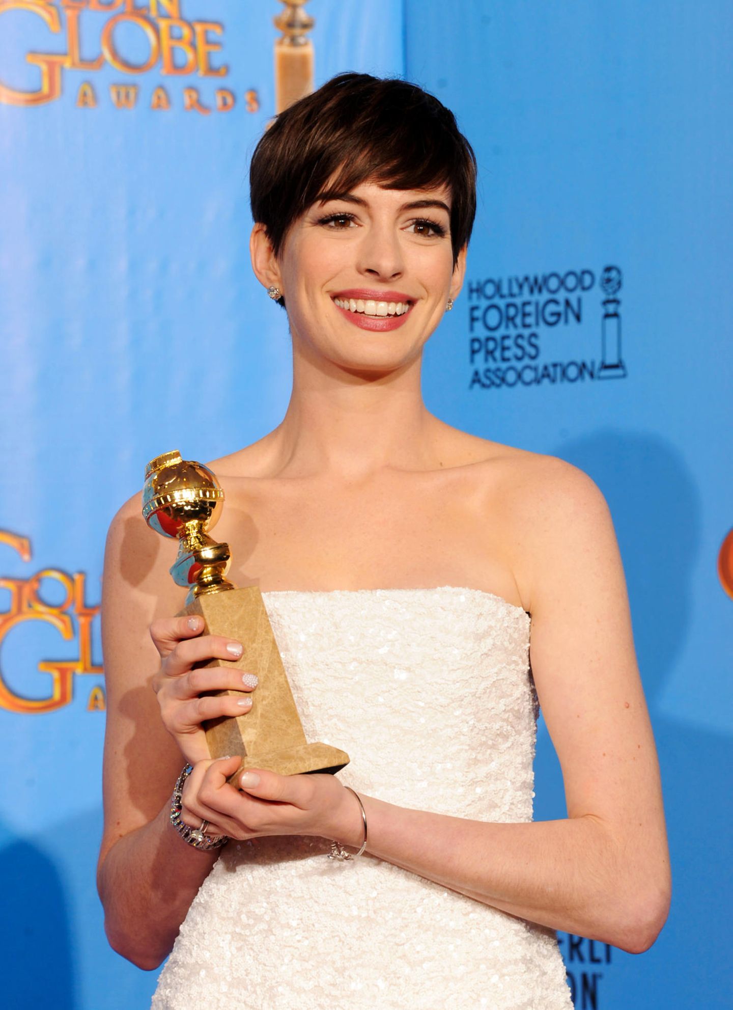 2013  In einem weißen Peplum-Kleid von Chanel strahlt die Preisträgerin bei den Golden Globe Awards. Anne wurde als beste Nebendarstellerin ausgezeichnet. 