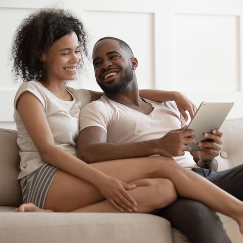 Glückliches Paar auf dem Sofa: Diese 2 Fähigkeiten sind zentral für eine erfolgreiche Beziehung