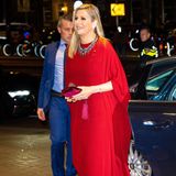 Erneut beweist Königin Máxima ihre Liebe für rote Teile und ausdrucksstarke Looks. Bei einer Musical-Performance für den italienischen Präsidenten erscheint sie in einer weiten roten Robe. Dazu kombiniert die 51-Jährige eine farbenfrohe Statement-Kette und eine bordeauxfarbene Clutch aus Samt. 