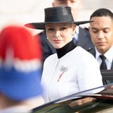 Fürstin Charléne zeigt sich in diesem Jahr in einem weißen Mantellook mit elegantem schwarzem Hut.