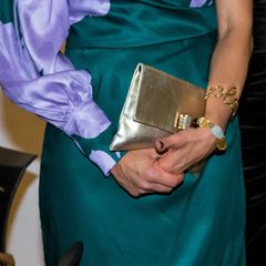 Bei dem unteren Armband handelt es sich um ein Schmuckstück, das Prinzessin Victoria bereits seit einigen Jahren in ihrer Schatulle aufbewahrt. Zuletzt führte sie es 2008 während ihres Besuchs in Indien aus. Es fügt sich prima in die Farbgebung des Kleides ein und greift den Gold-Ton der Tasche auf.