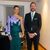 Normalerweise zeigt sich Prinzessin Victoria bei offiziellen Terminen wenig experimentierfreudig, setzt bei ihren Looks gerne auf Klassiker. Doch bei einer Dinnerparty während ihrer Staatsreise nach Nairobi wählt die schwedische Kronprinzessin ein auffälliges One-Shoulder-Kleid des schwedischen Labels By Malina mit einem extravaganten Blumenprint an Ärmel und Oberteil. Das Flaschengrün des Kleides harmoniert allerdings nur wenig mit Prinz Haakons Krawatte – der um einige Nuancen hellere Grünton passt so gar nicht zu dem des Kleides. Umso harmonischer ist allerdings Victorias Schmuck, der nicht nur perfekt auf das Kleid abgestimmt wurde...