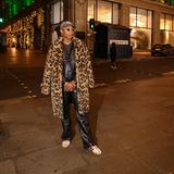 Pharrell Williams posiert vorm Londoner Nobel-Kaufhaus Selfridges in einem coolen Look bestehend aus Leder-Ensemble und Leo-Mantel. Dazu trägt er eine Sonnenbrille aus seiner Kollaboration mit Tiffany's, eine Cap und Adidas Samba-Sneaker. 