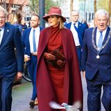 Beerentöne gehören für Königin Máxima im Herbst und Winter einfach dazu. Kein Wunder, immerhin stehen sie der gebürtigen Argentinierin bestens! Bei der Feier des 15. Jubiläums des Multicultureel Netwerk Rijksambtenaren in Den Haag am 24. November 2022 setzt die Königin auf eine glamouröse Kombination aus einem Cape von Maison Valentino und einem Mididress von Nathan Couture. Auch die Accessoires hält sie in Beerentönen. Kniehohe Boots von Gianvito Rossi und ein großer Hut im selben Farbton verleihen dem Look eine zusätzliche Prise Drama. Da möchte sogar eine Taube noch mit ihr auf dem Bild sein.