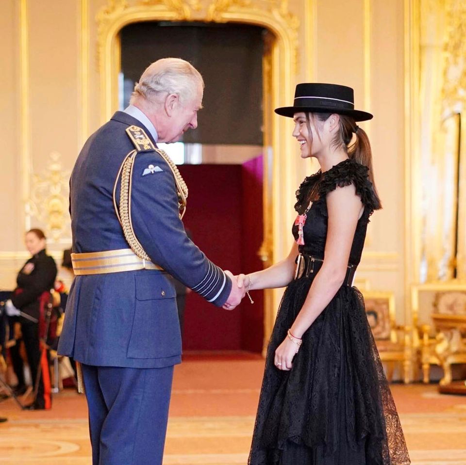 König Charles kann der Tennisspielerin Emma Raducanu während der Investitur auf Schloss Windsor nicht nur zur ihrem MBE-Orden gratulieren, sondern auch zu ihrem stylischen schwarzen Spitzenlook.