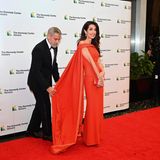 In diesem Kleid ist sie der Star! Das scheint Ehemann George Clooney ganz genauso zu sehen und richtet auf dem roten Teppich des Kennedy-Preises, der ihm an diesem Abend verliehen wird, liebevoll die Schleppe von Amal Clooneys Traumrobe in Rot. Sichtlich dankbar für die Hilfe ihres Mannes ist die Menschenrechtsanwältin nach ein paar wertvollen Handgriffen dann auch bereit, ihr gesamtes Wow-Outfit aus Off-Shoulder-Kleid, goldener Clutch und Perlenschmuck in Perfektion zu präsentieren.