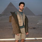 Baptiste Giabiconi, Model und frühere Muse von Karl Lagerfeld, zeigt sich vor den Pyramiden von Gizeh in einem Set aus kurzen Cargohosen, Weste und Windjacke. Dazu kombiniert er hohe Stiefel – natürlich von dem französischen Label.