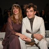 Hand in Hand und ganz verliebt zeigen sich Suki Waterhouse und Robert Pattinson in der Front Row der Dior Herbst/Winter Menswear Show in Kairo. Sie setzt auf ein semitransparentes Tüllkleid, er auf einen sandfarben Anzug von Dior. 