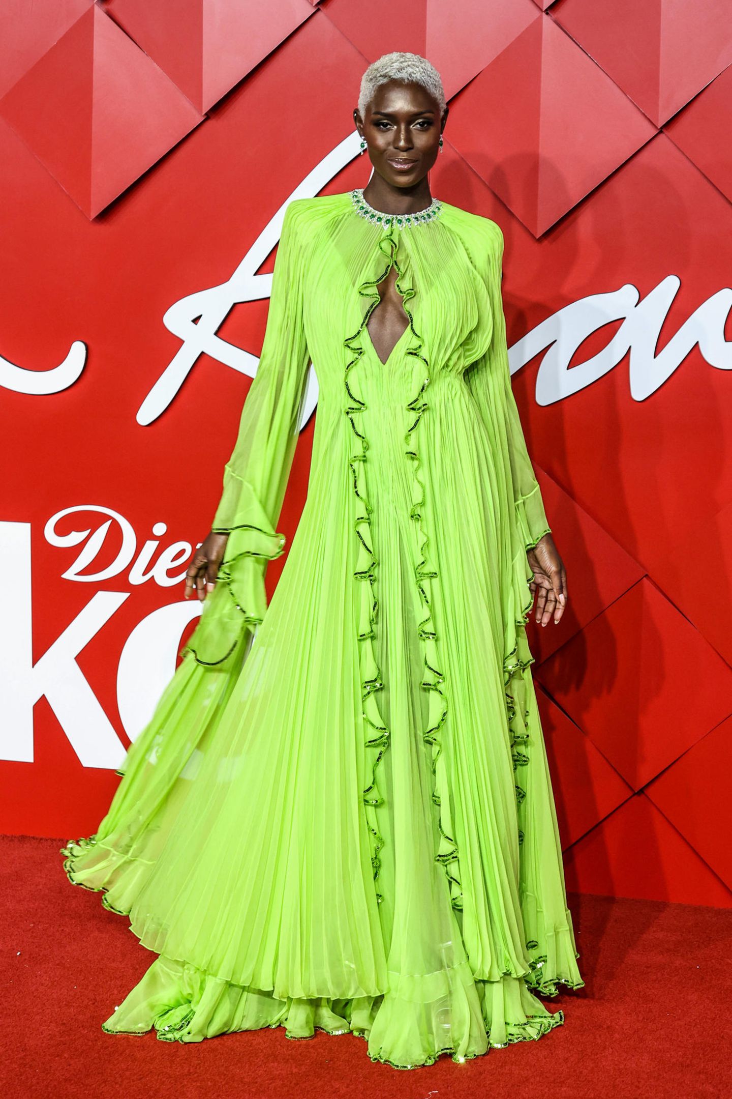 In diesem Neon-Traum sieht Schauspielerin Jodie Turner-Smith einfach umwerfend aus! Das grüne Chiffon-Kleid von Gucci hat einen tiefen V-Ausschnitt mit semitransparentem Kragen und lange Ärmel.