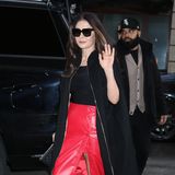 Catherine Zeta-Jones winkt auf dem Weg zu einem Auftritt in der Show "Live with Kelly & Ryan" in New York City in die Kamera. Sie trägt einen roten Lederrock mit Knopfleiste und ein schwarzes Oberteil. Dazu kombiniert die "Morticia Addams"-Darstellerin aus der neuen "Wednesday"-Serie einen schwarzen Mantel und rote Lack-Pumps.
