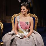Eine der extravagantesten Roben trägt Prinzessin Victoria bei der Verleihung im Jahr 2018. Das dreifarbige Kleid kommt mit einer Korsage und einem ausladenden Rock im Prinzessinnen-Stil daher. 