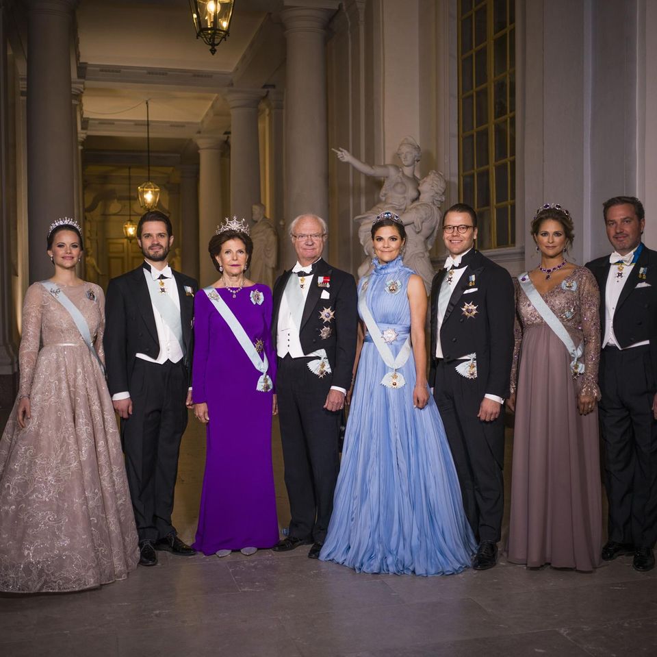 Im Jahr 2017 zeigen sich die schwedischen Royals einmal mehr von ihrer glamourösen Seite. Während Silvia und Victoria auf farbige Roben setzen, erscheinen Sofia und Prinzessin Madeleine in gedeckten Erdtönen. Letztere ist zu dem Zeitpunkt schwanger mit ihrer jüngsten Tochter Adrienne.