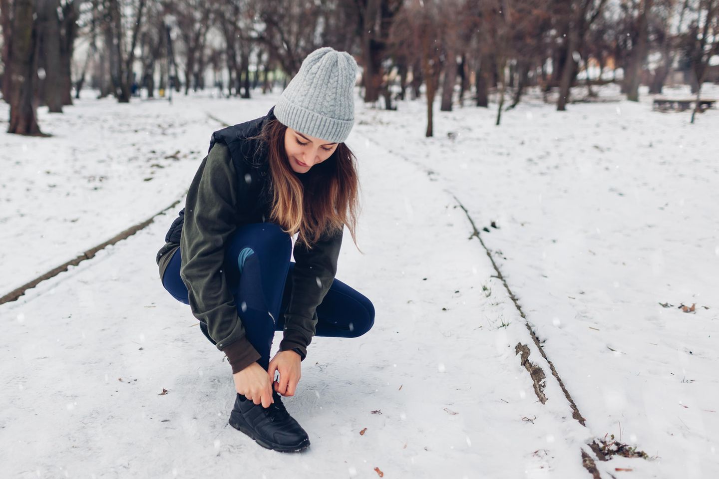 Die perfekten schwarzen Sneaker: 4 Modelle für die kalte Jahreszeit, junge Frau im Schnee