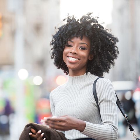 Lächelnde Frau in der Stadt: Diese 5 Eigenschaften haben optimistische Menschen gemeinsam