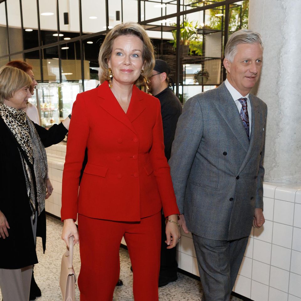 Im weihnachtlichen Rot besucht Königin Mathilde gemeinsam mit König Philippe die Betreuungsgruppe Heilig Hart in Kortrijk. Zu ihrem roten Hosenanzug trägt sie große goldene Ohrringe und spitze Stilettos. Ihre Accessoires in Beige halten sich dezent im Hintergrund und geben dem Anzug seine verdiente Aufmerksamkeit. Ob Santa Clause da neidisch wird? 