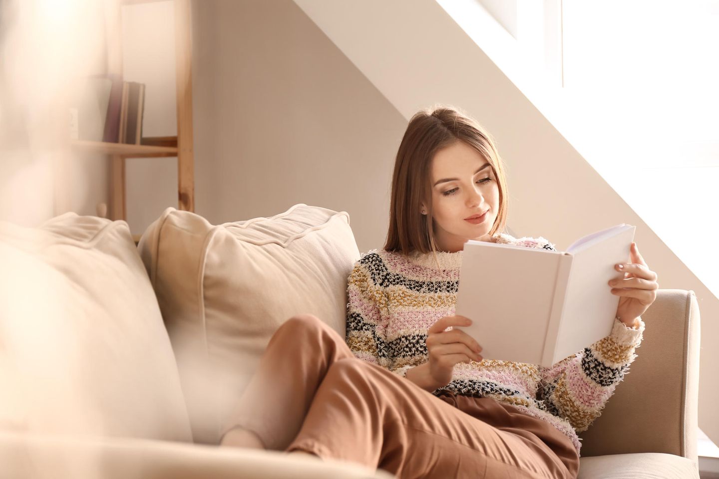 Frau liest Buch auf dem Sofa, Bestseller