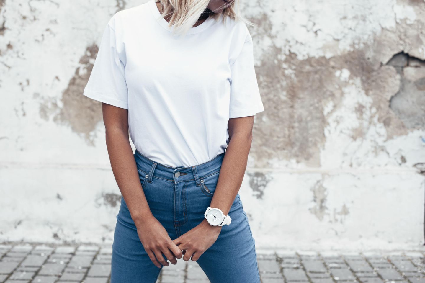 Die perfekte Skinny Jeans: Wie trägt man sie 2023? Frau in Blue Jeans und weißem T-Shirt