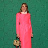 Einen farblich kräftigen Kontrast zeigt Modejournalistin Anna Dello Russo im pinkfarbenen Satin-Dress mit Ratsherren-Kragen vor der grünen Gucci-Wand.